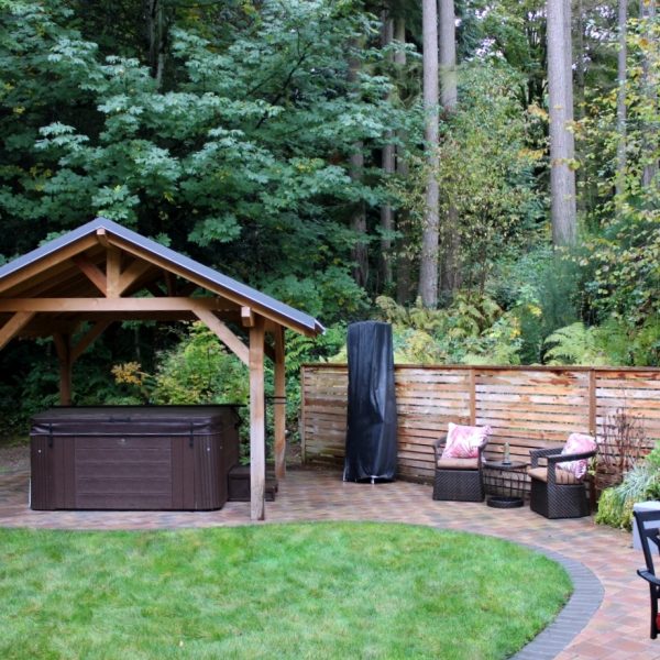 View of the soothing S-curve and lawn that envelopes the hot tub area and the lounge area. Note the charcoal paver edge in soldier course along the patio edge.